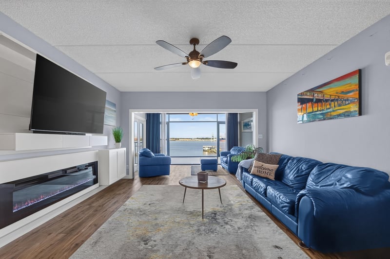 Living room with wall-mounted TV and blue sofa at 2280 Shepard St