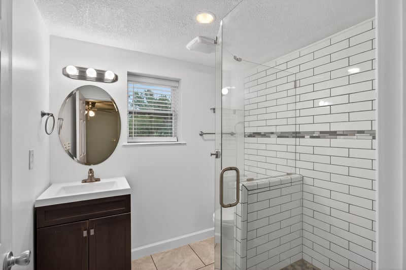 Bathroom vanity with walk-in shower finished in subway tile at 1619 Hammond Blvd, Jacksonville, FL