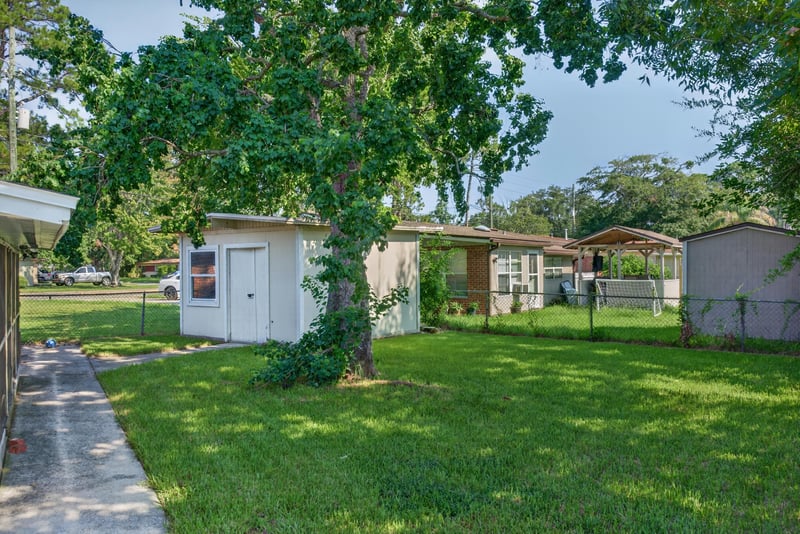 Backyard with shed, lawn and mature trees at 5503 Boeing Dr, Jacksonville, FL 32207