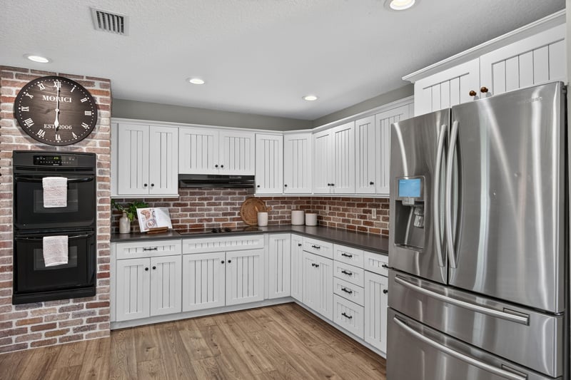Kitchen with stainless refrigerator and brick accent at 1161 Whispering Pines Rd, Jacksonville, FL 32259