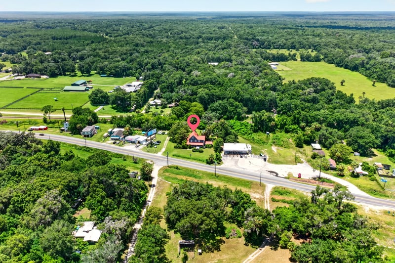 Aerial view of surrounding farmland and tree line in Satsuma, FL