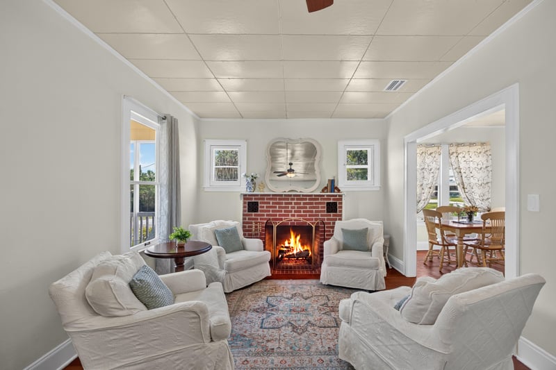 Living room with lit brick fireplace and armchairs at 101 N Lake St, Crescent City, FL
