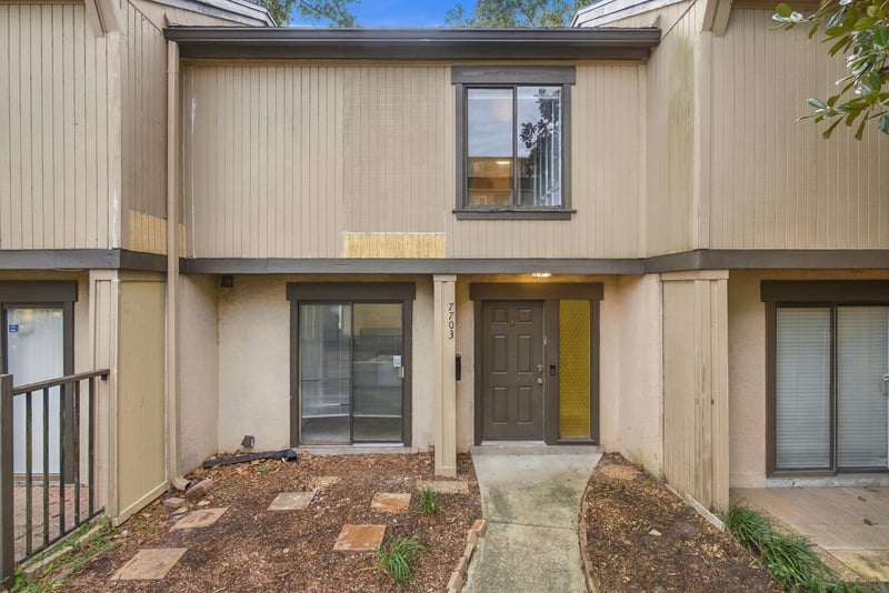 Front exterior with tan stucco and wood siding at 7703 Las Palmas Way