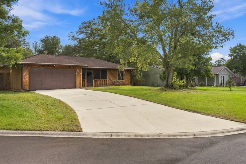Front exterior along curved driveway and lawn at 2915 Trenton Ct, Orange Park, FL