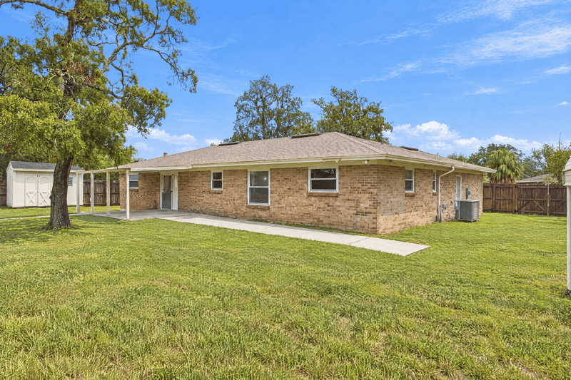 Rear exterior wide view of brick home and yard at 357 Dillon Dr, Orange Park, FL