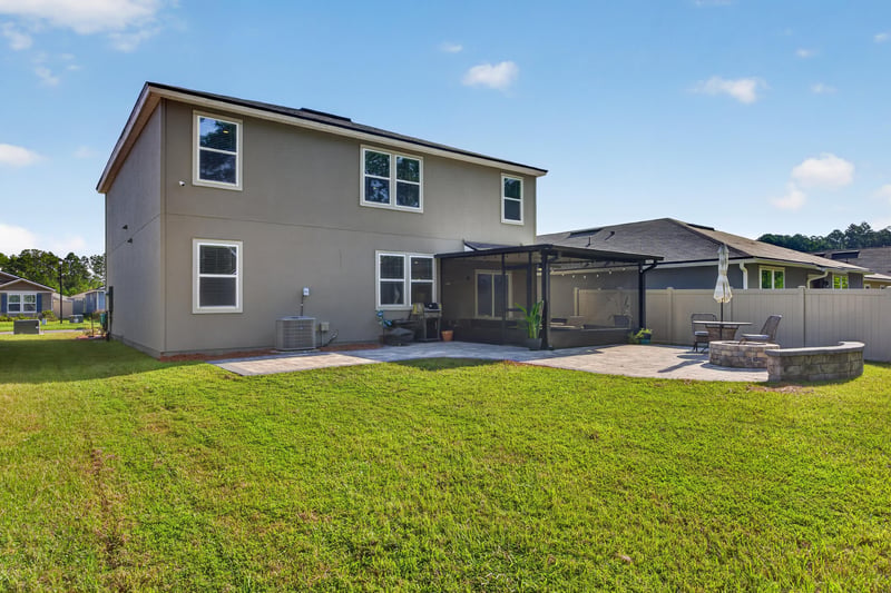 Rear exterior with screened porch and patio at 65255 Frst Glen Ln, Yulee, FL 32097