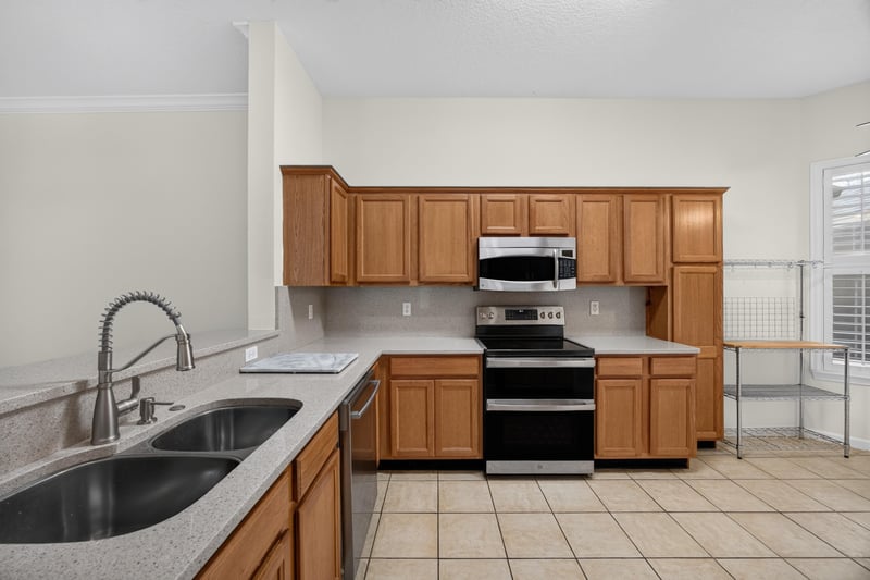 Kitchen with stainless sink, cooktop, and tile floor at 2131 E Stone Creek Dr, Fleming Island, FL