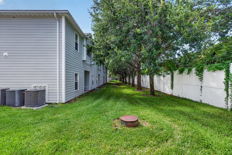 Side yard with trees and lawn at 7047 Deer Lodge Cir, Jacksonville