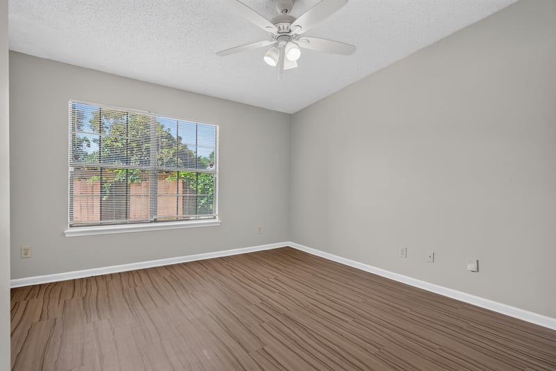 Bedroom with window and wood-look flooring at 8010 International Village Dr, Jacksonville, FL 32277