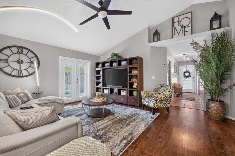 Living room open to kitchen with wood floors at 3067 Wavering Ln, Middleburg, FL 32068
