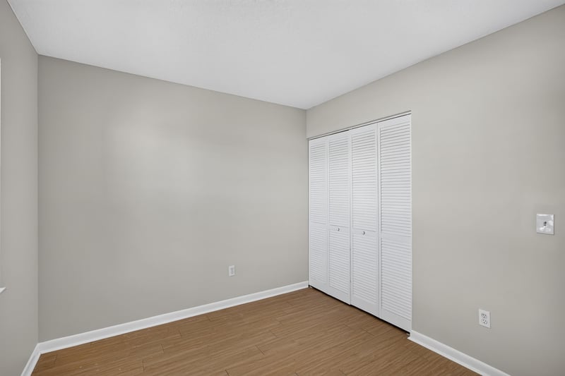 Bedroom with closet and wood-look flooring at 700 W Pope Rd unit h61, St. Augustine, FL 32080