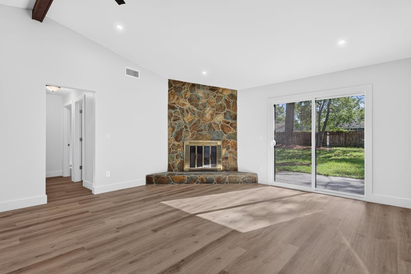 Living room with stone fireplace and sliding glass doors to backyard at 8453 Boysenberry Ln W, Jacksonville, FL