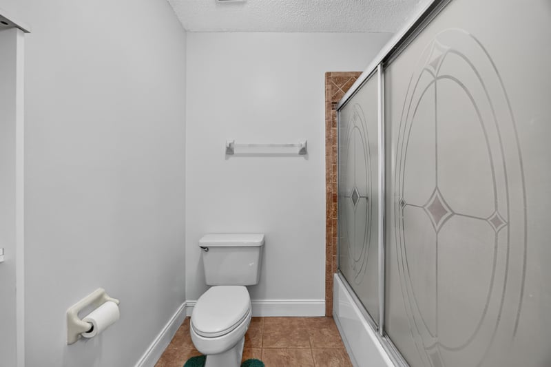 Bathroom with toilet and glass shower door at 2435 Range Line Rd, Middleburg, FL