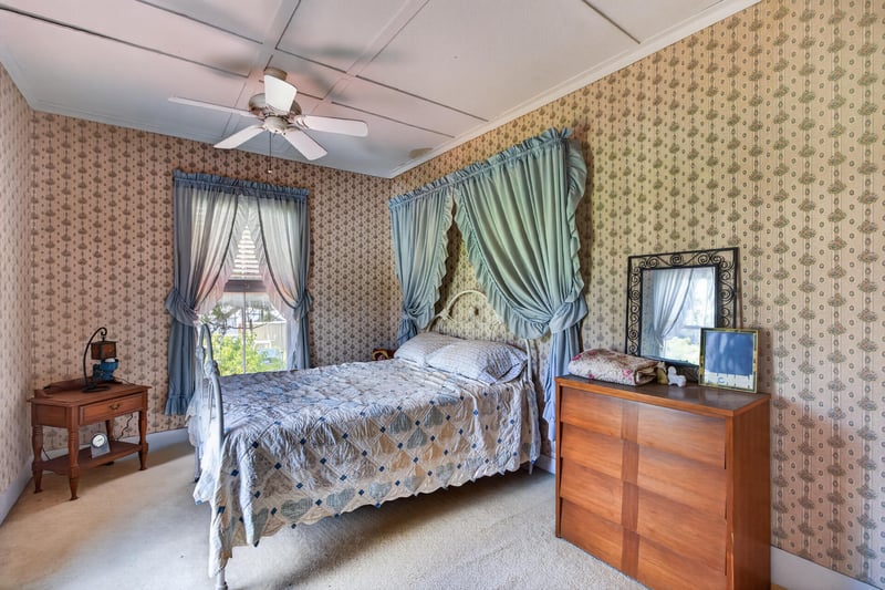 Bedroom with wallpaper and blue curtains at 1173 US-17, Satsuma, FL 32189