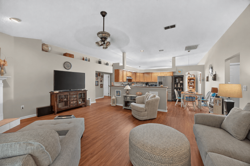 Living room with vaulted ceiling and wall-mounted TV at 13514 Las Brisas Way N, Jacksonville, FL