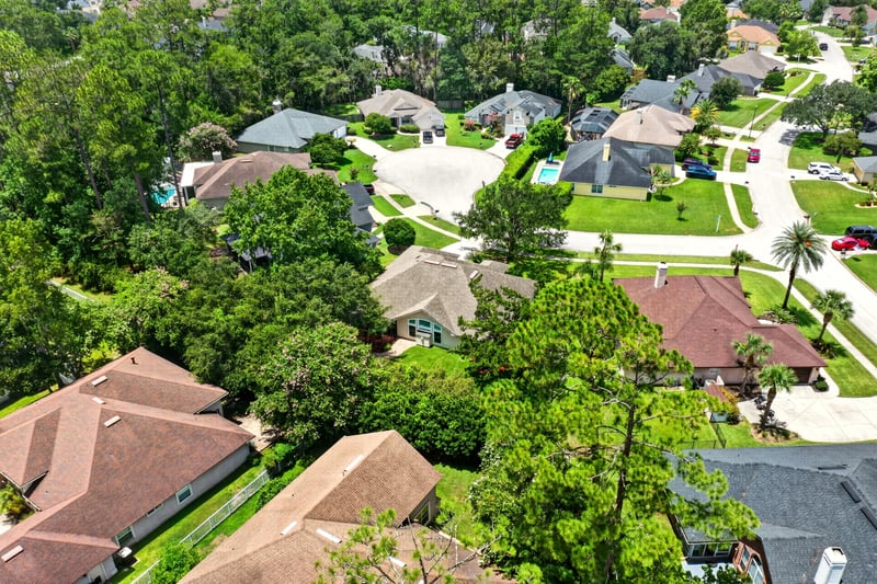 Aerial view of neighborhood rooftops and trees in Fleming Island, FL