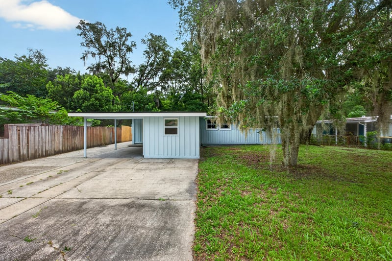 Front exterior showing driveway and Spanish moss-draped oaks at 3113 Kline Rd, Jacksonville, FL 32246