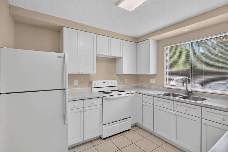 Kitchen with white appliances and tile floor at 5811 Atlantic Blvd unit 47, Jacksonville, FL 32207