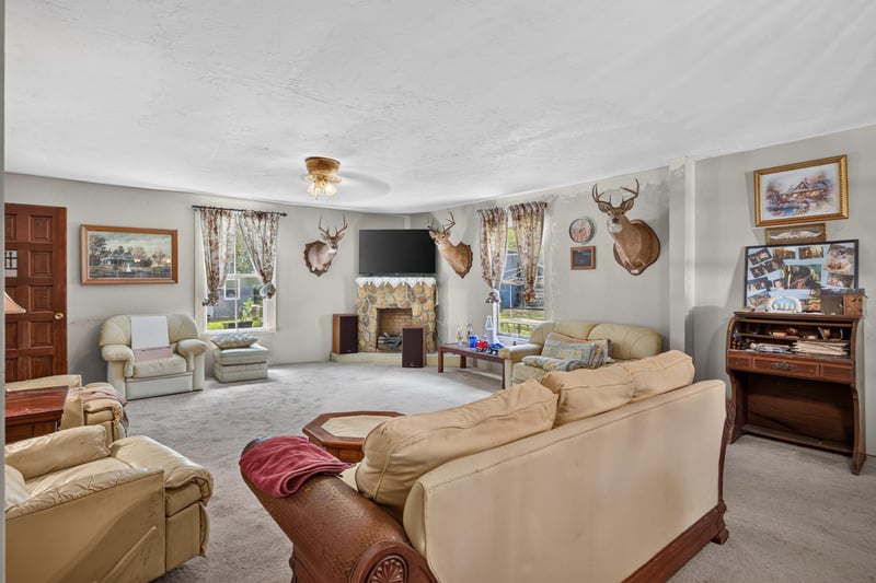 Living room with fireplace and mounted deer trophies at 1173 US-17, Satsuma, FL 32189