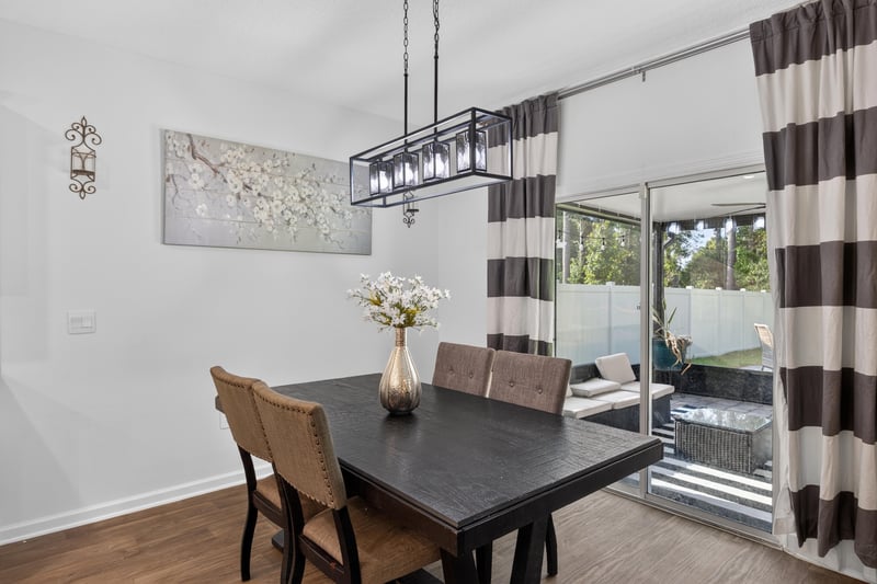 Dining area with striped curtains and slider to backyard at 65255 Frst Glen Ln, Yulee, FL 32097