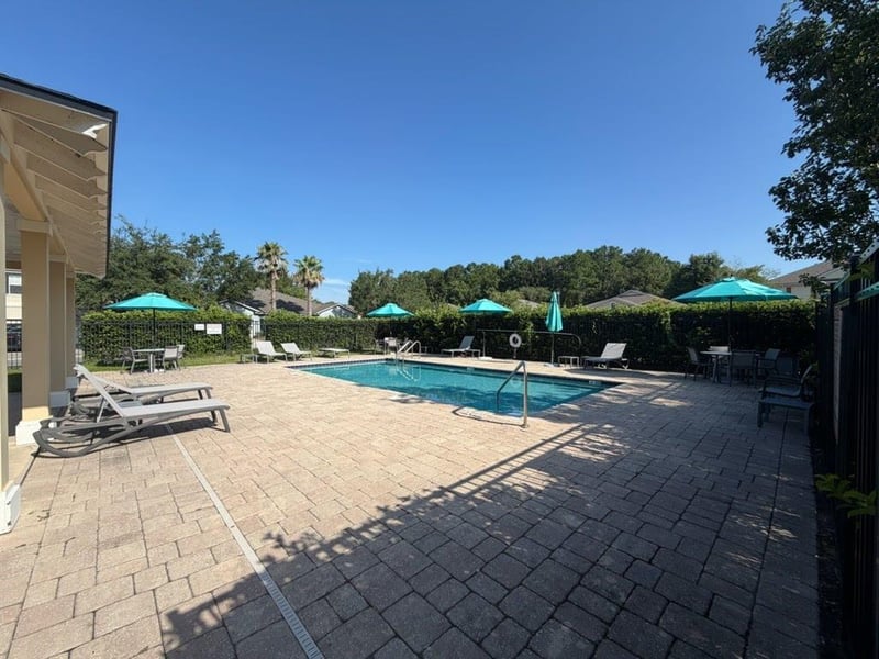 Community pool with lounge chairs and umbrellas in Jacksonville, FL