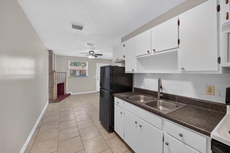 Kitchen view toward living room with white cabinets at 8067 Parental Cir, Jacksonville, FL 32216