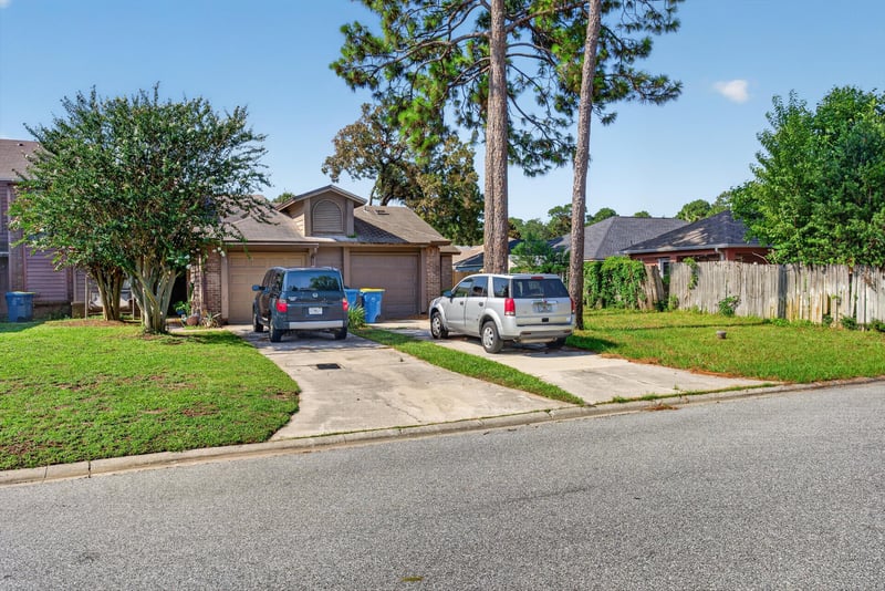 Front exterior with driveway and parked cars at 8010 International Village Dr, Jacksonville, FL 32277