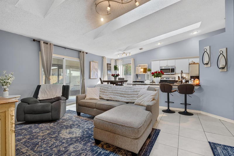 Living room with vaulted ceiling and dining area beyond at 13020 Medford Ln, Jacksonville, FL 32225