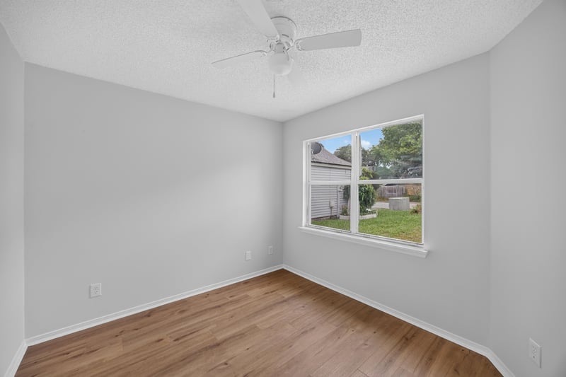 Empty bedroom with corner window at 8047 Mactavish Way E, Jacksonville, FL 32244