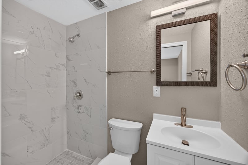 Bathroom with marble-tile shower and vanity at 184 Draco St, Orange Park, FL 32073
