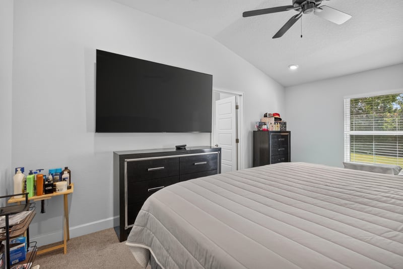 Primary bedroom with wall-mounted TV at 9846 Olivia St, Jacksonville, FL