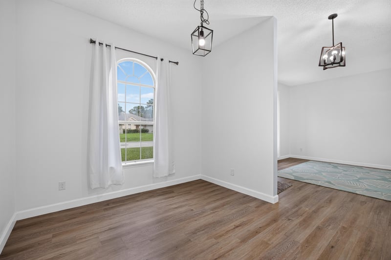 Living room corner with arched window at 8921 Needlepoint Pl, Jacksonville, FL 32244