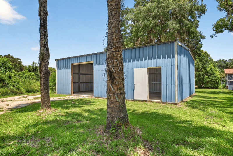 Blue metal barn with overhead door at 1173 US-17, Satsuma, FL 32189