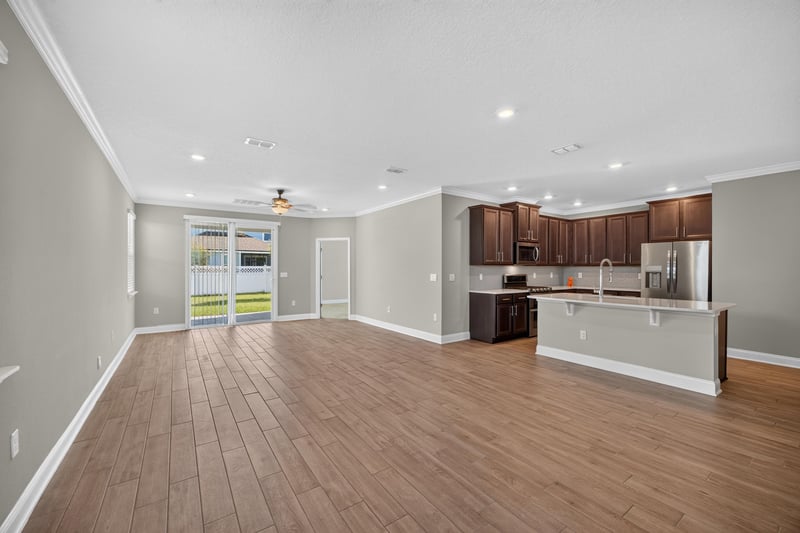 Living area with ceiling fan and open sightline to kitchen at 331 Millerstone Dr, St. Augustine, FL 32092