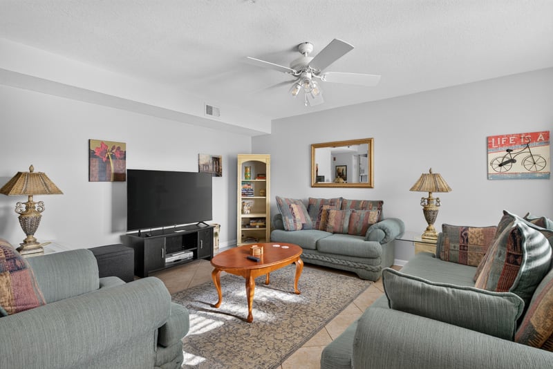 Living room with sofa, television stand and mirror at 206 16th St, St. Augustine, FL 32080
