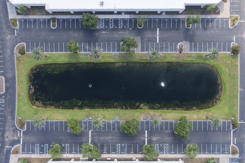 Aerial view of a pond with fountain between parking lots at 10550 Deerwood Park Blvd, Jacksonville, FL 32256