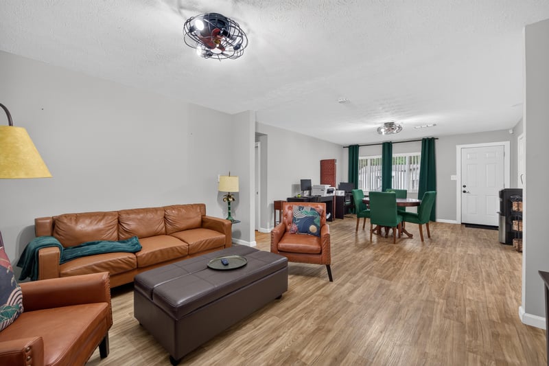 Living room with leather sofas and wood-look flooring at 9506 Harriet Ave, Jacksonville, FL 32208
