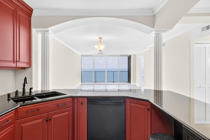 Kitchen sink area with red cabinets and window at 1301 1st St S