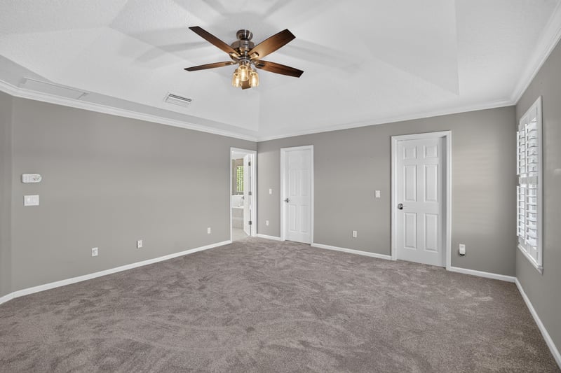 Primary bedroom with ceiling fan and carpet at 1493 Greyfield Dr, St. Augustine, FL 32092