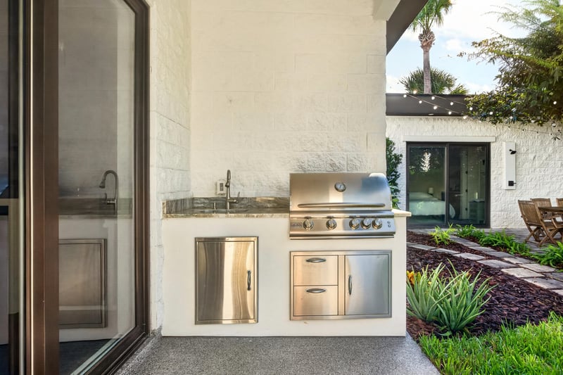 Outdoor kitchen with built-in grill and stone counter at 722 3rd Ave N, Jacksonville Beach, FL