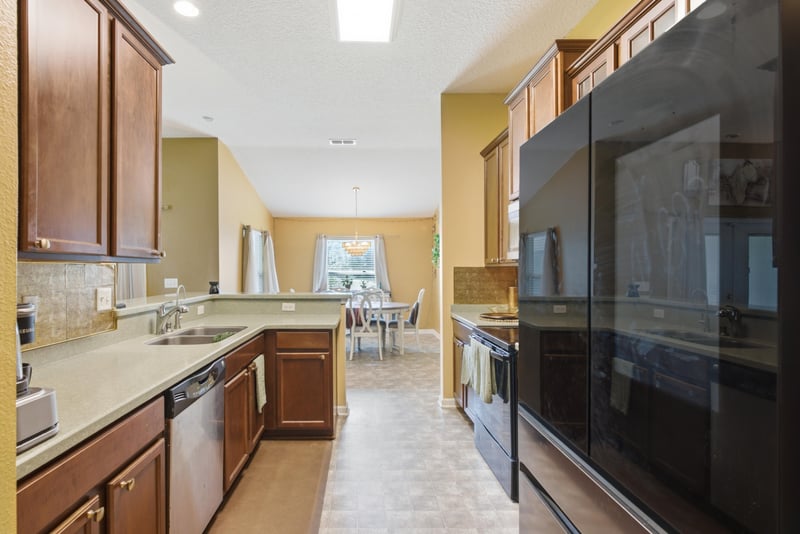 Kitchen view with dark cabinets and wall-mounted TV at 7392 Timber Falls Ct