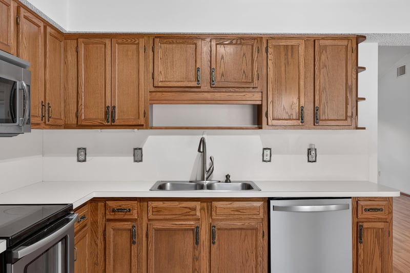 Kitchen sink area with oak cabinetry and dishwasher at 2460 San Sago Ln, Jacksonville, FL