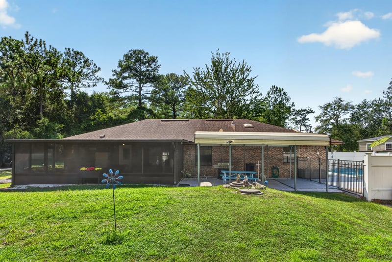 Screened pool enclosure and backyard lawn at 2435 Range Line Rd, Middleburg, FL