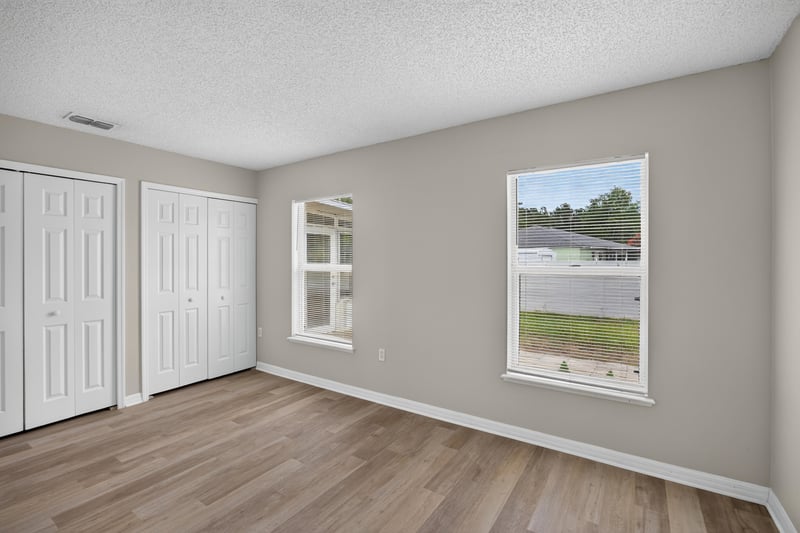 Bedroom with closet doors and window at 1845 Saga Ct, Middleburg, FL
