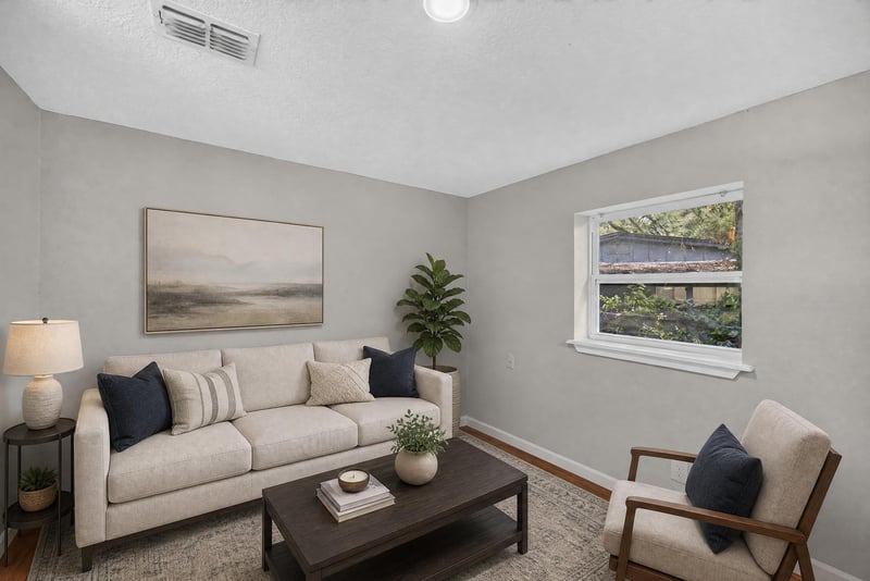 Virtually staged living room with sofa and window at 7015 Miss Muffet Ln N, Jacksonville, FL 32210