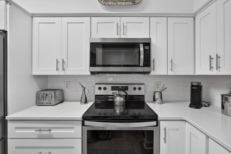 Kitchen cabinets, microwave, and tile backsplash at 10435 Mid Town Pkwy unit 135, Jacksonville, FL 32246