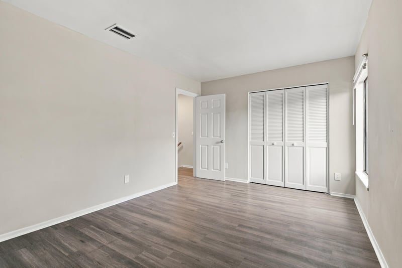 Bedroom with closet doors and wood-look floor at 7703 Las Palmas Way