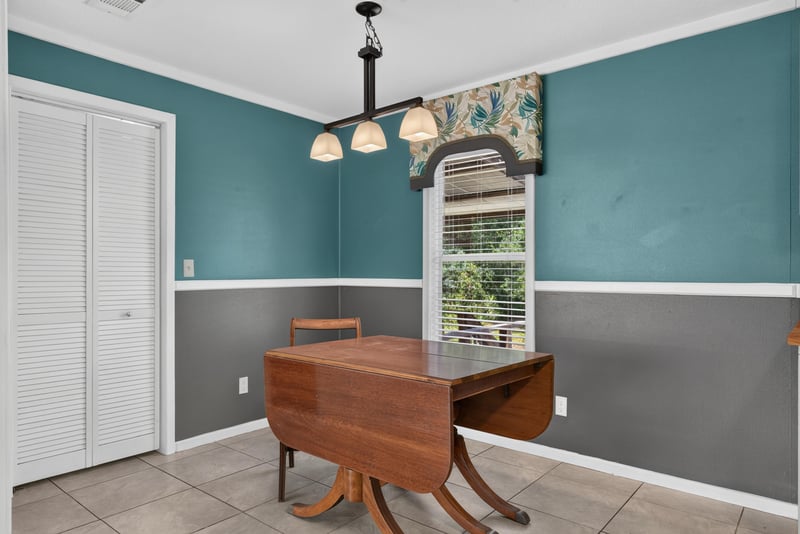 Dining nook with wood table and teal walls at 2549 Snapdragon Ave, Middleburg, FL 32068