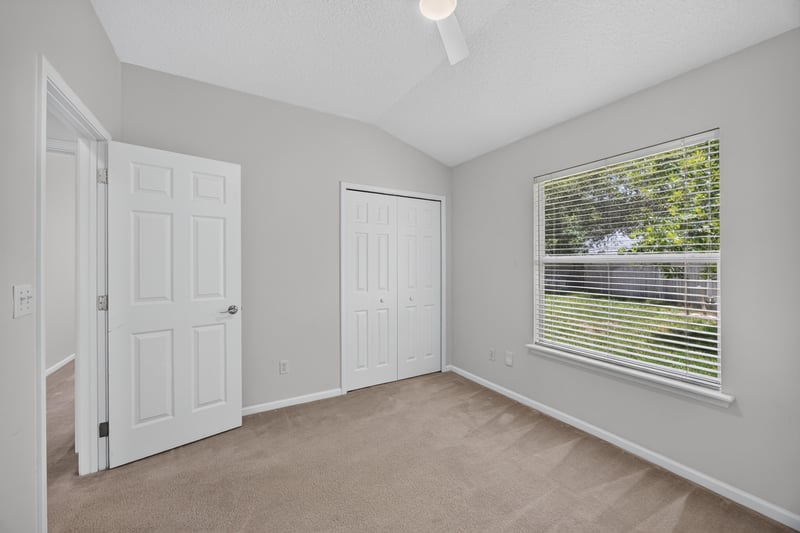 Bedroom with closet doors and window at 2480 Ridge Will Dr, Jacksonville, FL 32246