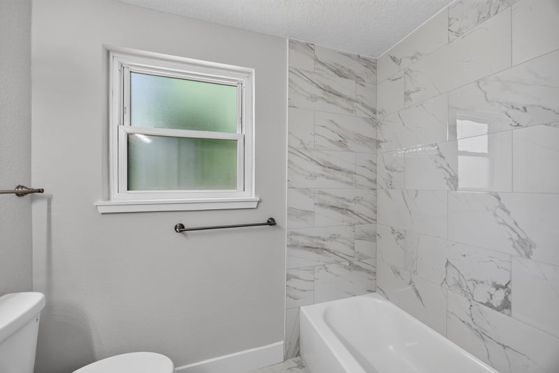 Bathroom with tub and marble-look surround at 6238 Randia Dr, Jacksonville, FL 32210